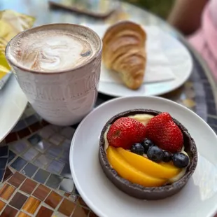 a cup of coffee and a fruit tart