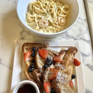 a plate of french toast and a bowl of strawberries