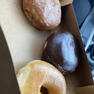 A glazed doughnut, a Boston cream, and a strawberry filled