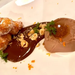 Nutella chocolate custard with beignets, chocolate sauce, and nuts