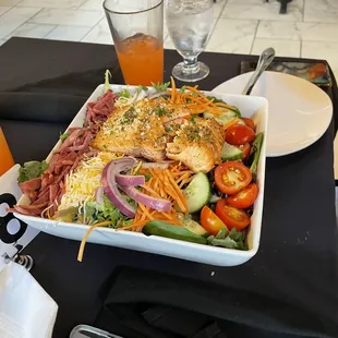 a plate of salad and a glass of orange juice