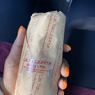 a hand holding a sandwich