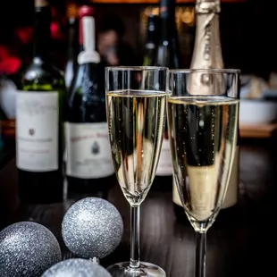 two glasses of champagne and a bottle of wine