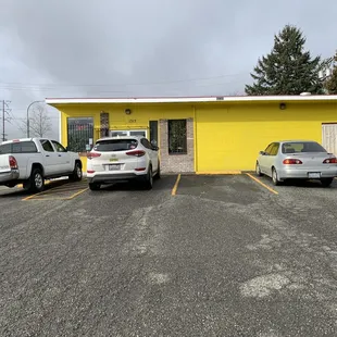 Entrance beyond the cars in the parking lot.