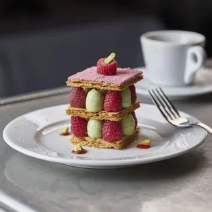 a stack of desserts and a cup of coffee