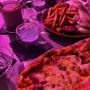 a pizza and french fries on a table
