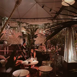 a group of people sitting at a table under a tent