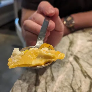 a person holding a spoon full of food