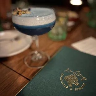 a blue cocktail in a coupe glass