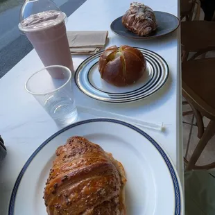 entire order including an almond croissant, ham and cheese croissant, garlic and cream cheese bun, and a strawberry smoothie