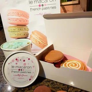 A pint of almond macaron gelato, a lavender white chocolate and a rose macaron, a raspberry chocolate mini cake and lemon tart to go