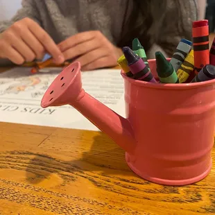 Cute little watering can with crayons they give to color their kids menu