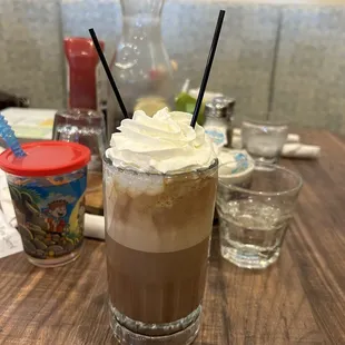 a glass of iced coffee with whipped cream