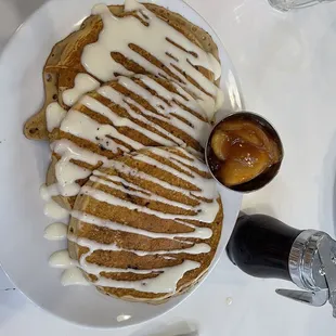 a plate of pancakes with a drizzle of icing