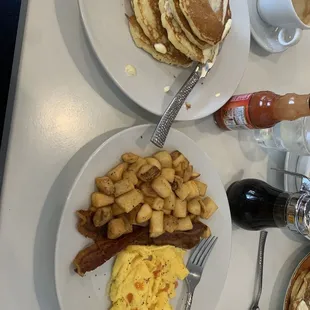 a breakfast of pancakes, eggs, hash browns and coffee