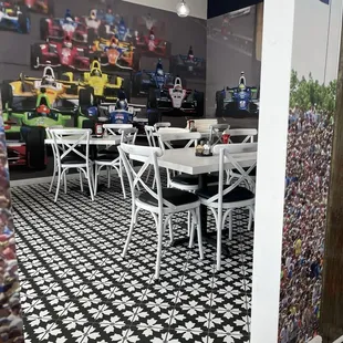 a black and white tile floor with white chairs and tables