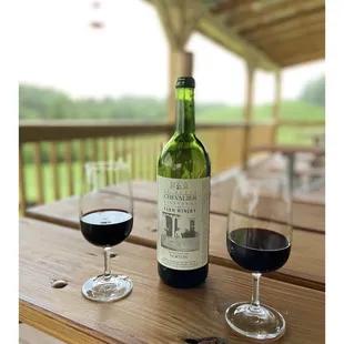 a bottle and two glasses of wine