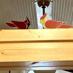 a red cardinal perched on top of a wine rack