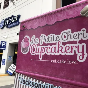 a woman standing in front of a food truck
