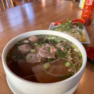 a bowl of beef soup and a plate of noodles