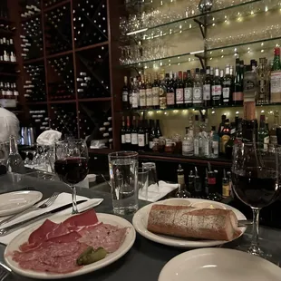 a plate of meat and bread on a bar