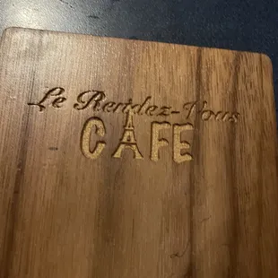 a cutting board with the word cafe written on it