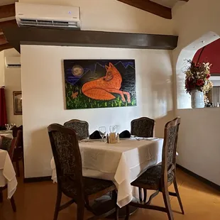 a dining room with a painting on the wall