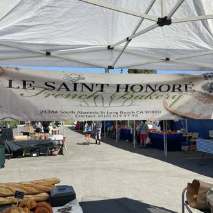an outdoor market with bread and pastries