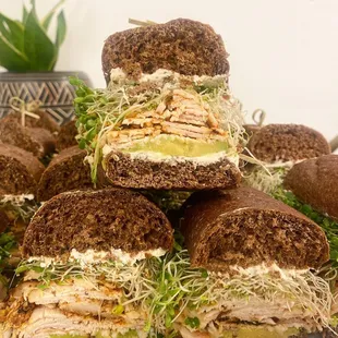 a pile of sandwiches with meat and veggies