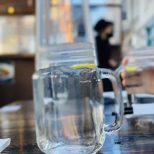 a glass of water with a slice of lemon in it