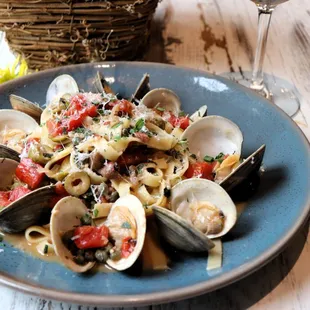 FETTUCCINE &amp; CLAMS $27
Little Neck Clams, Olives, Capers, Fired Roast Tomato, Cracked Pepper, Basil, Parmigiano Reggiano.