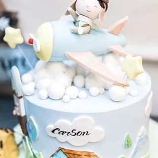 a cake with a boy on top of it