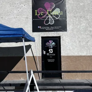 a table with a blue tent and a sign that says le umu umu