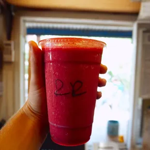 a hand holding a red drink