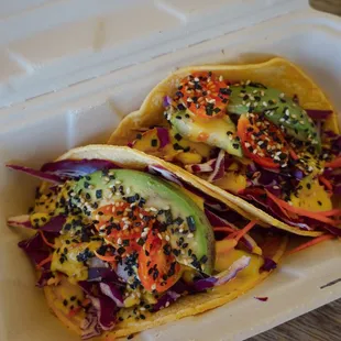 two tacos in a styrofoam container