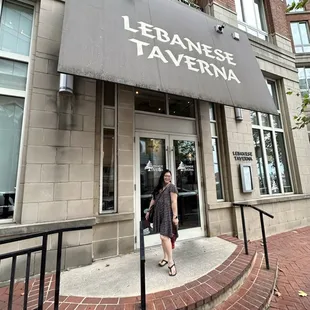 a woman standing in front of a restaurant