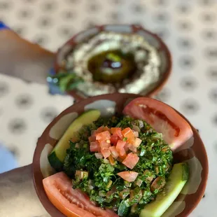 a plate of food with tomatoes and cucumbers