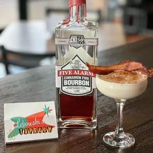 a bottle of five alarm bourbon and a glass of bacon