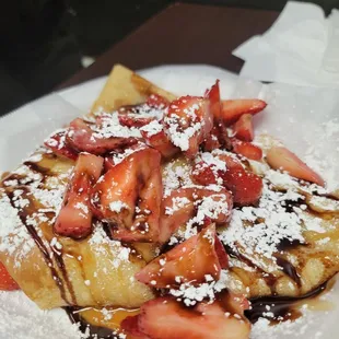 a plate of french toast with strawberries and chocolate sauce