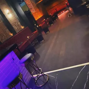 an empty bar with purple lighting