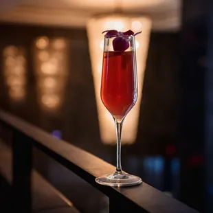 a glass of wine with a cherry garnish