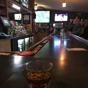 a glass of whiskey on the bar