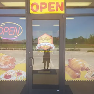 a man standing in front of a donut shop