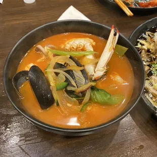 a bowl of seafood soup and a bowl of rice