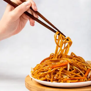 a plate of noodles with chopsticks