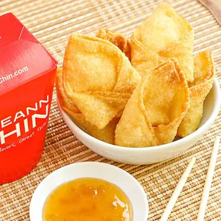 a bowl of wonton chips and a bowl of dipping sauce