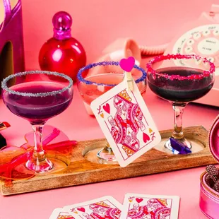 a pink background with a pink phone, a card case, a pair of high heels,