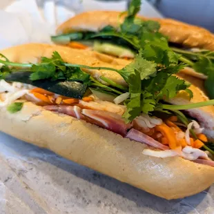 Two banh mi dac biet. Cost less than $12 after tax before tip on Sunday, August 11, 2024.