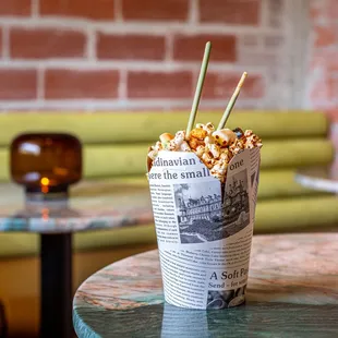 a cup of popcorn on a table