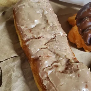 The old guy put the maple bar at the bottom of the paper bag and squished it